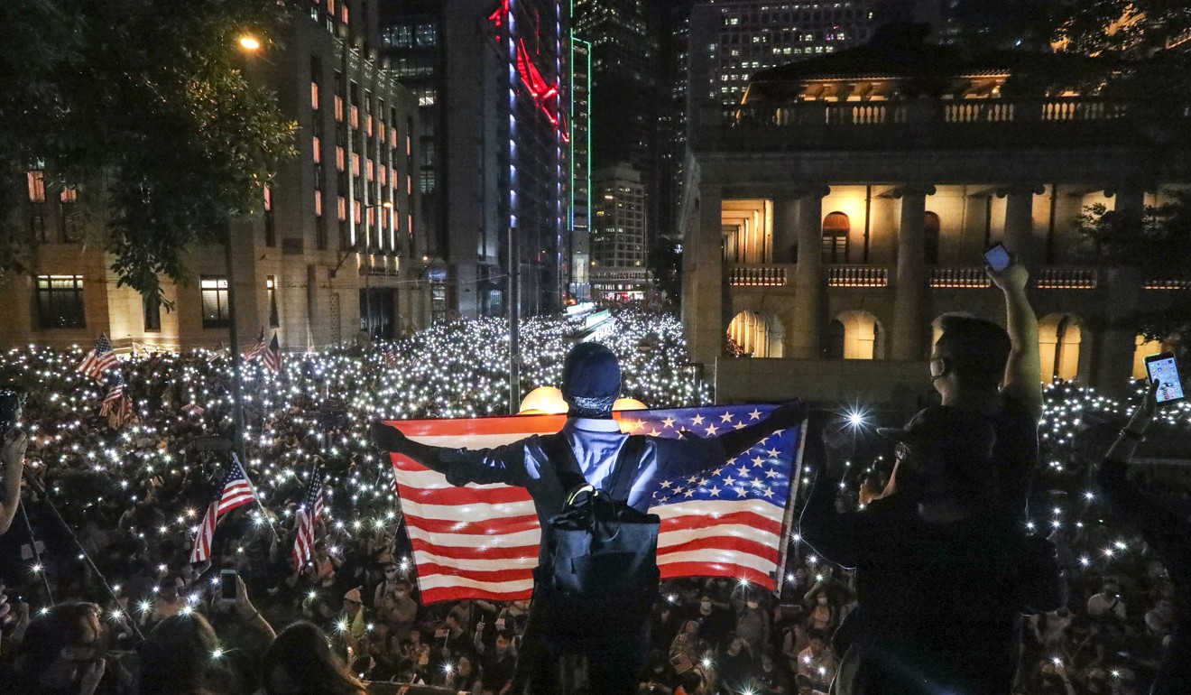 Anti-government protesters wave American flags during a protest in Central on Monday. Photo: Felix Wong