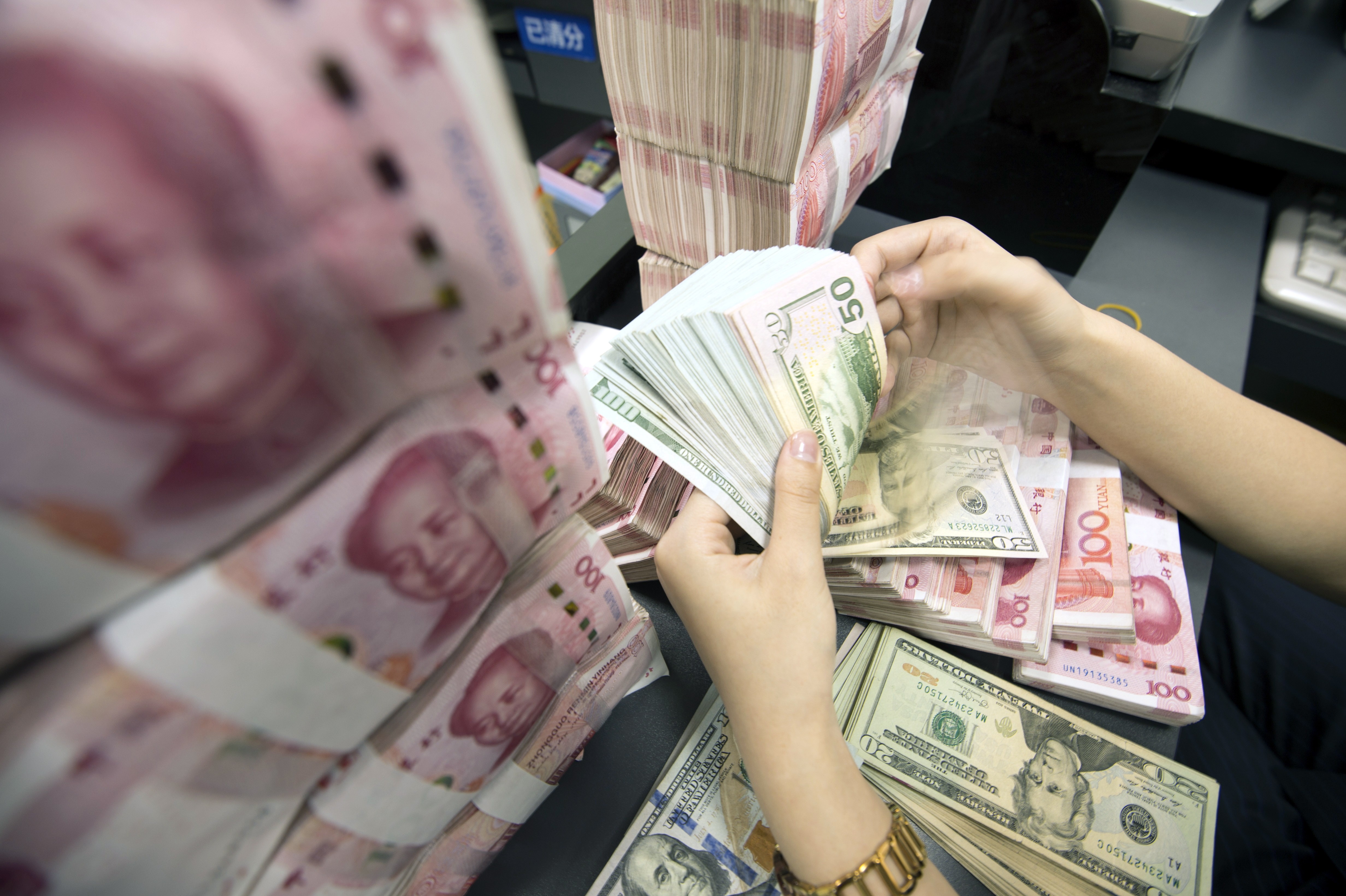 Тысяча долларов в юанях. Renminbi Yuan. Валюта Китая. Финансовые операции в юанях. Руки с деньгами юань.