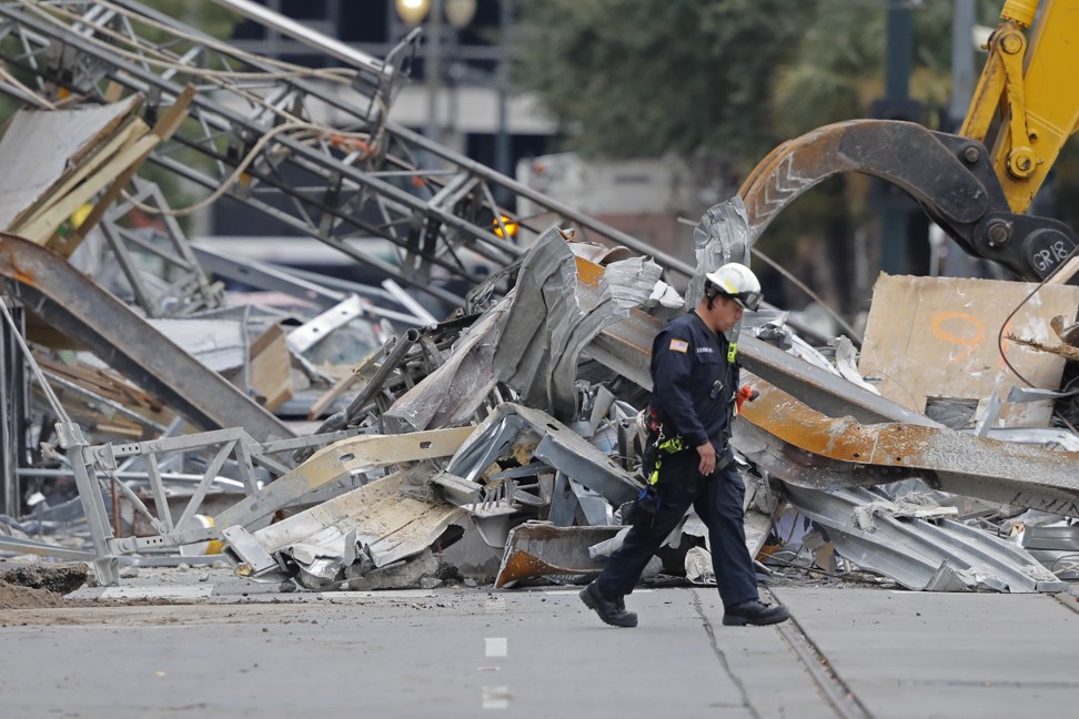 A worker walks in front of rubble in the street at the site of the Hard Rock Hotel in New Orleans after a storm. Photo: AP