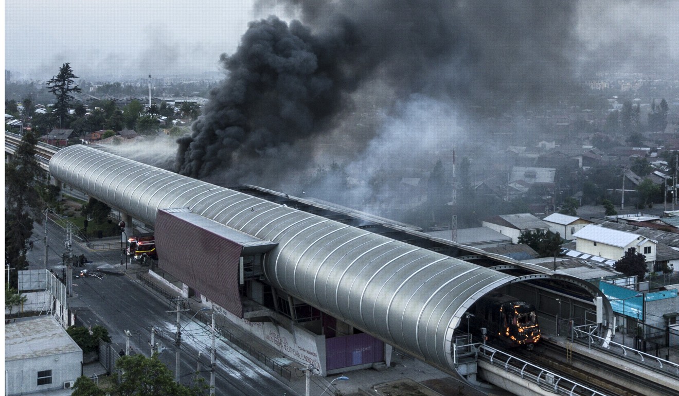 A burnt metro station amid protests in Santiago. Photo: AFP