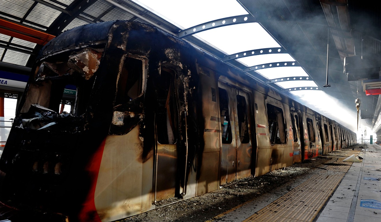 A burnt train after protests in Santiago. Photo: AFP