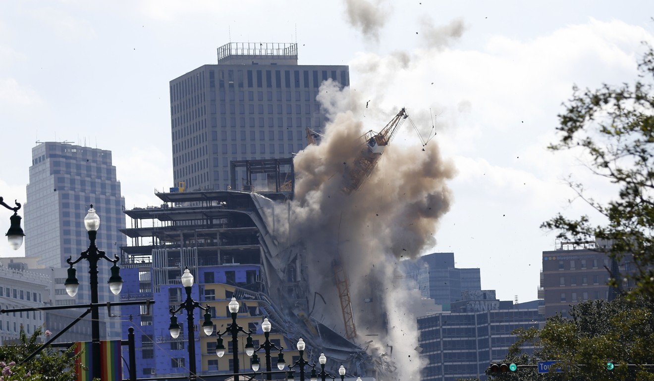 Two large cranes from the Hard Rock Hotel construction collapse come crashing down after being detonated in New Orleans. Photo: AP Photo