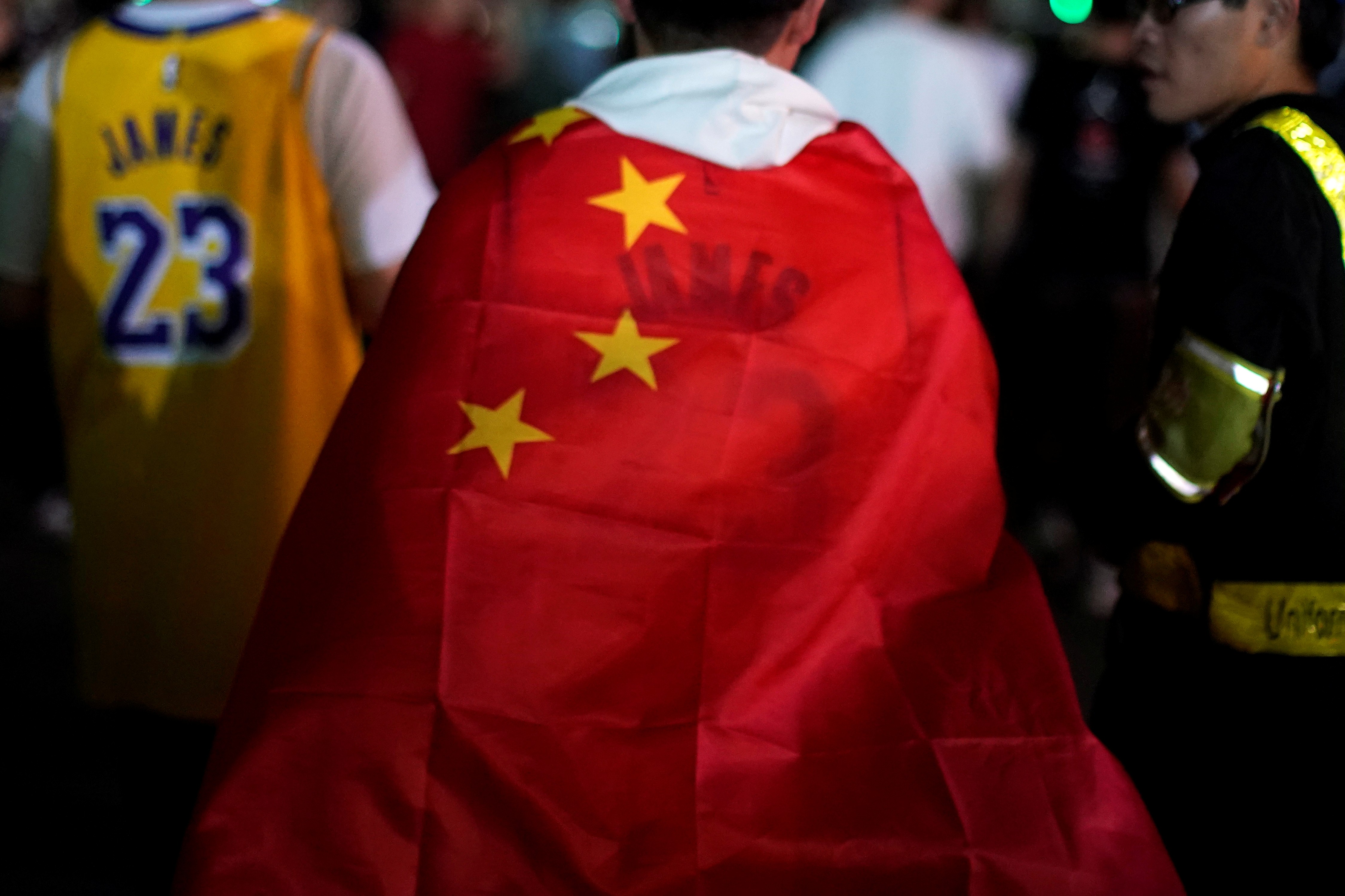 A man wearing a LeBron James jersey wraps himself in a Chinese national flag outside the Mercedes-Benz Arena before the NBA exhibition game between the Brooklyn Nets and Los Angeles Lakers in Shanghai on October 10. Photo: Reuters