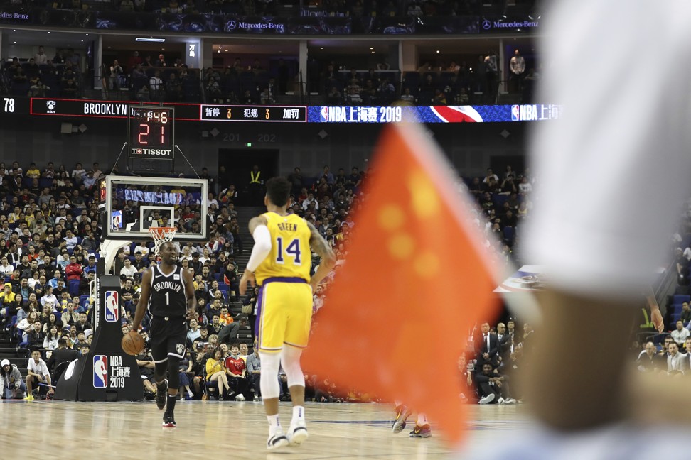 Brooklyn Nets Theo Pinson (left) drives against Los Angeles Lakers Danny Green, near a Chinese national flag during a preseason NBA game at the Mercedes-Benz Arena in Shanghai on October 10. Photo: AP