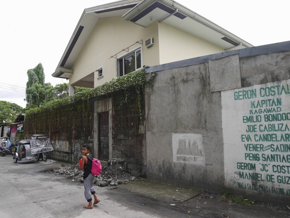 A child walks past the “magic door” of Douglas Slade’s house in Angeles City, in the Philippines. Photo: Red Door News