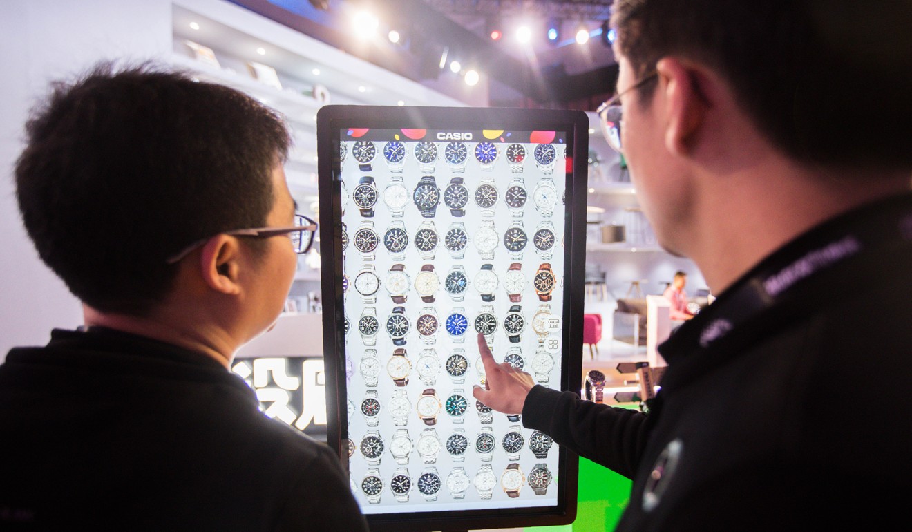 People select watches on an electronic screen at an exhibition during the Singles Day shopping festival in Shanghai on November 11, 2017. Photo: AFP