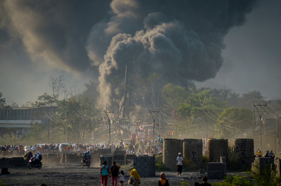 Locals watch as smoke rises from a fire on a pipeline near Bandung. Photo: Antara Foto via Reuters