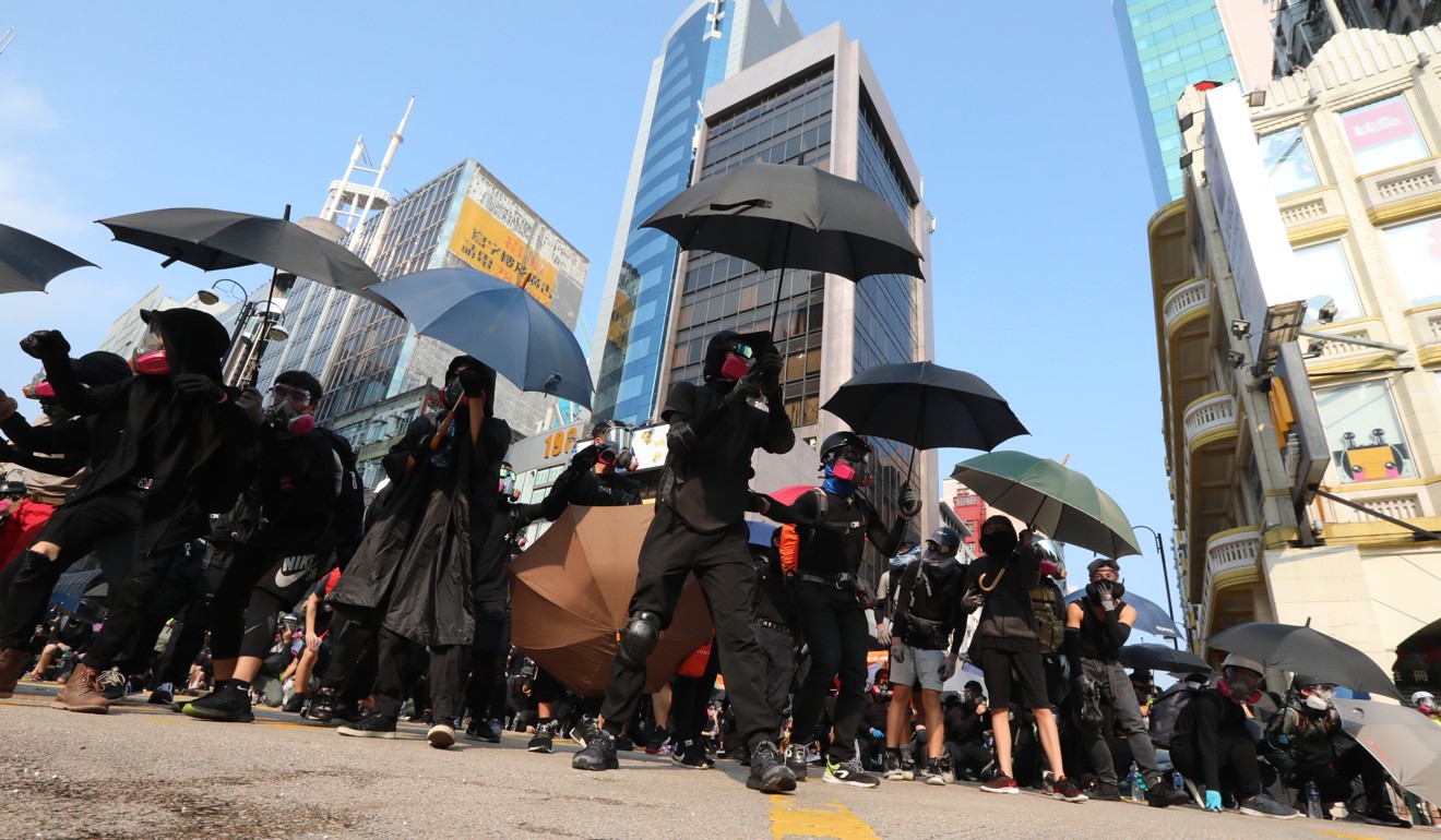 Anti-government protesters struggle with anti-riot police outside of the police station in Tsim Sha Tsui, a hub for tourism in the city. Photo: Felix Wong