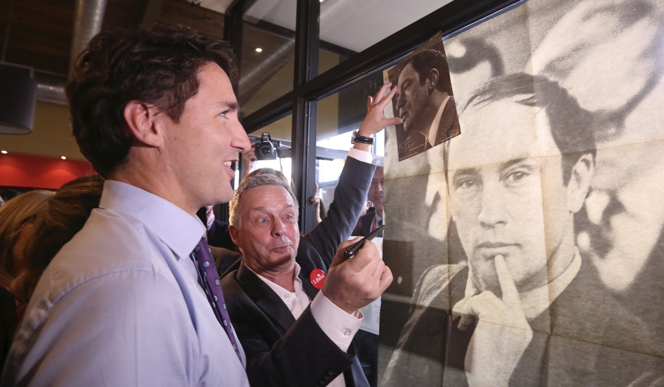 Justin Trudeau looks at a poster of his late father, former prime minister Pierre Trudeau, during a campaign in Sainte-Therese, Quebec. Photo: Reuters