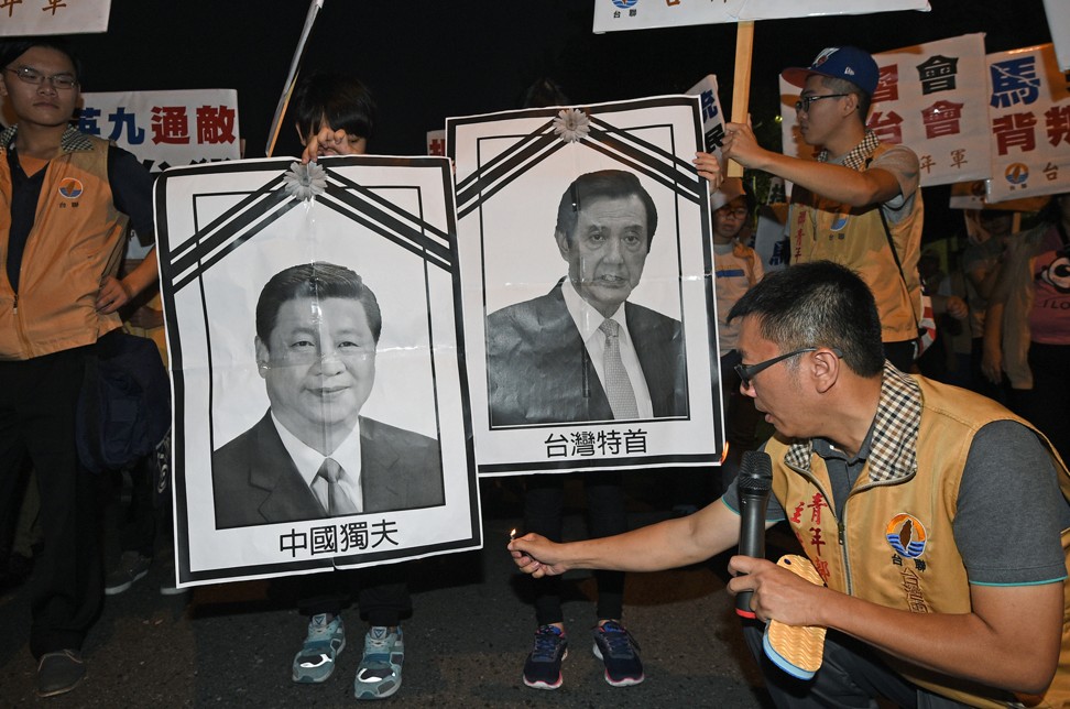 A Taiwanese independence activist sets fire to portraits of Xi and Ma during a demonstration in Taipei, in 2015. Photo: AFP