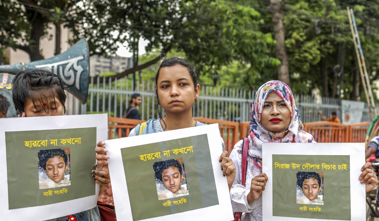 Women hold placards with a photograph of Nusrat Jahan Rafi at a protest following her death. Photo: AFP