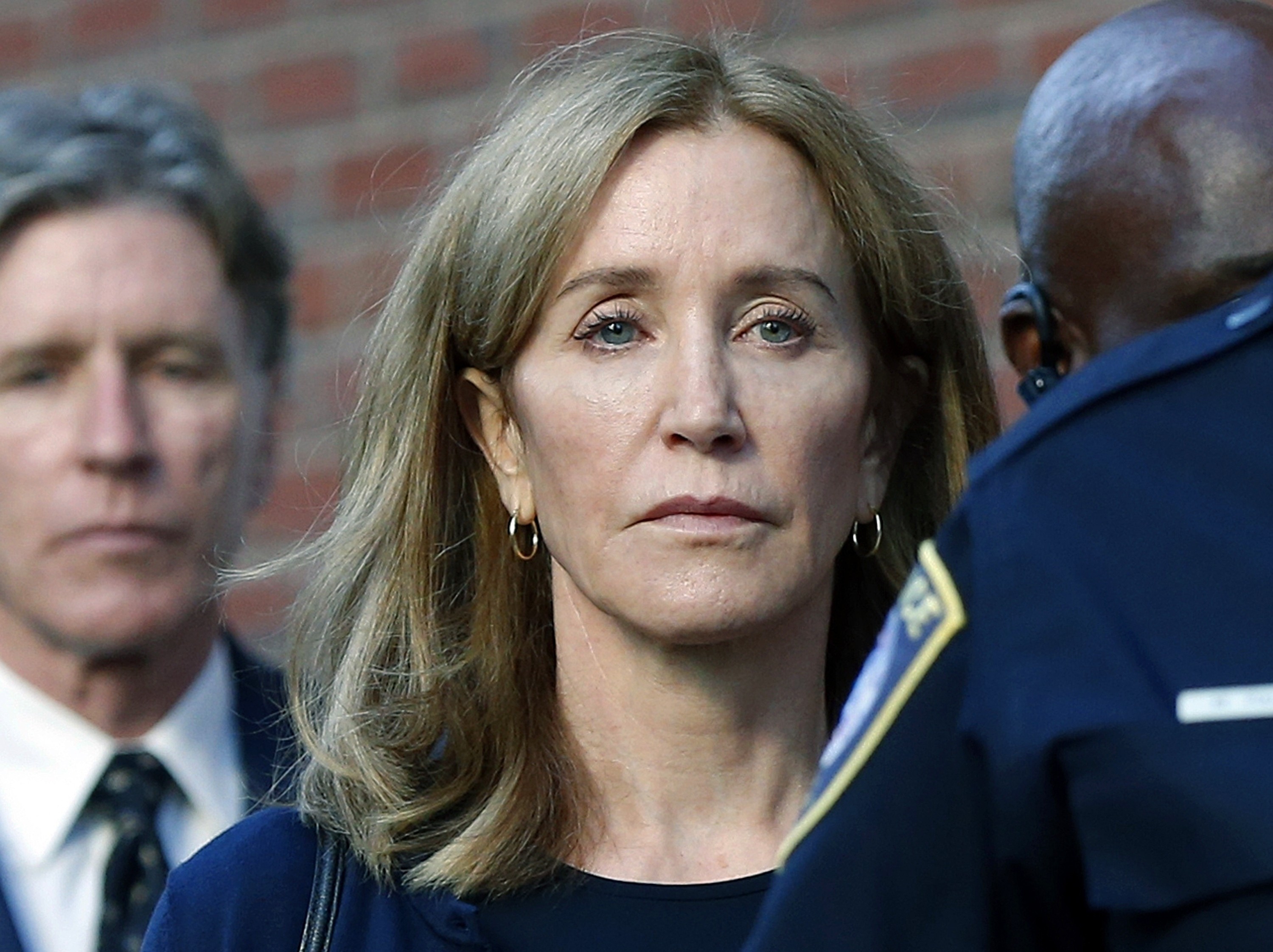 Actress Felicity Huffman leaves federal court in Boston with her brother Moore Huffman Jnr (left) in September, after she was sentenced in a nationwide college admissions bribery scandal. Photo: AP