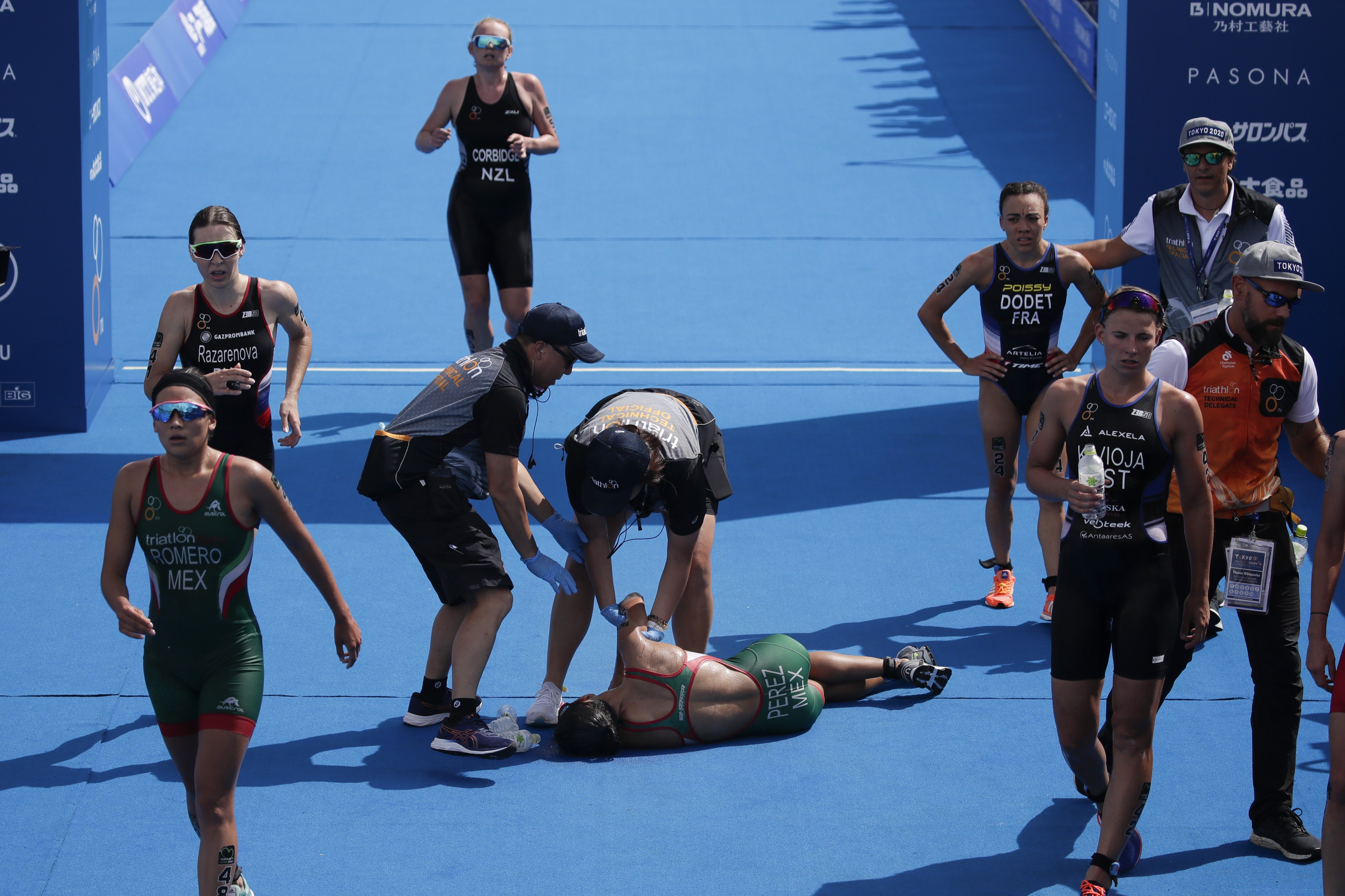 Mexico's Cecilia Perez (centre) collapses after competing in a women's triathlon test event at Odaiba Marine Park, a venue for marathon, swimming and triathlon at the Tokyo 2020 Olympics. Photo: AP