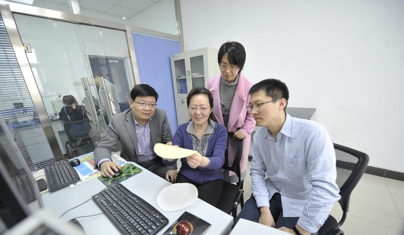 Professor Zhang Meiyun (centre, seated) and her team inspect samples of paper made using fly ash, a waste product from coal-fired power stations. Photo: Shaanxi University of Science and Technology