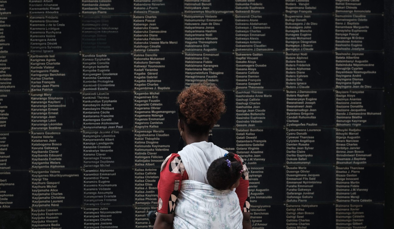 A woman carrying her child looks at the wall of victims' names as Rwanda marks the 25th Commemoration of the 1994 Genocide, in Kigali on April 8. Photo: AFP