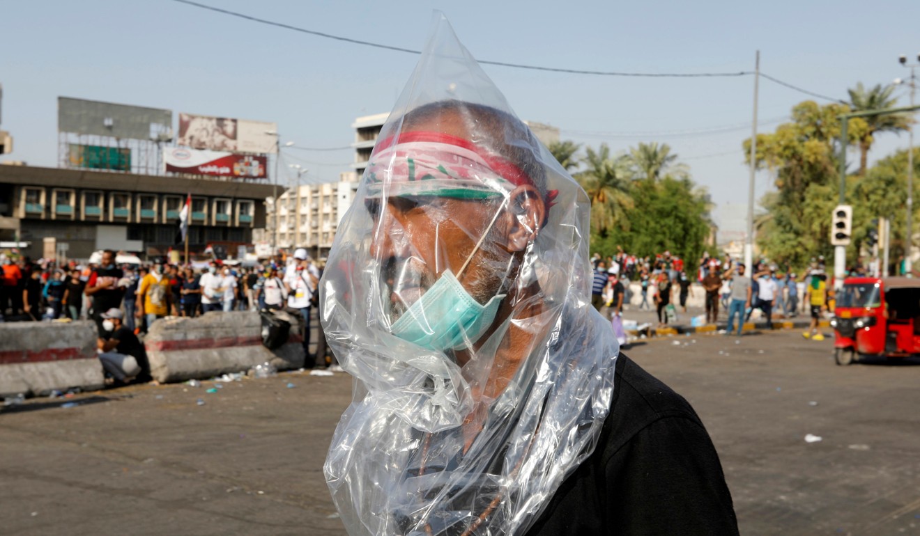 A man wears a plastic bag to protect himself from tear gas in Baghdad. Photo: Reuters