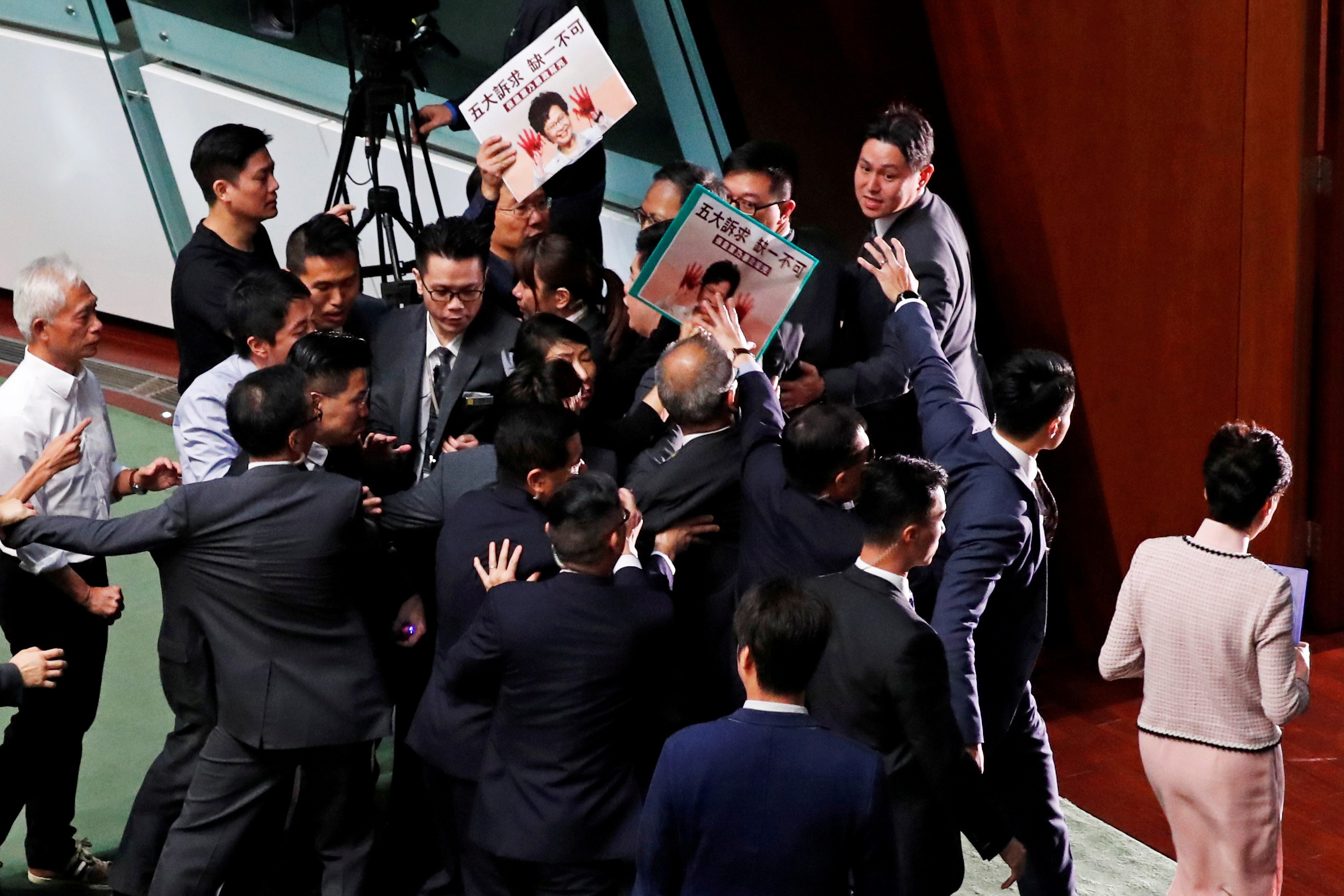 Chief Executive Carrie Lam leaves the Legislative Council chamber on October 16 without presenting her policy address after opposition lawmakers disrupt proceedings. The address was later delivered via video. Photo: Reuters