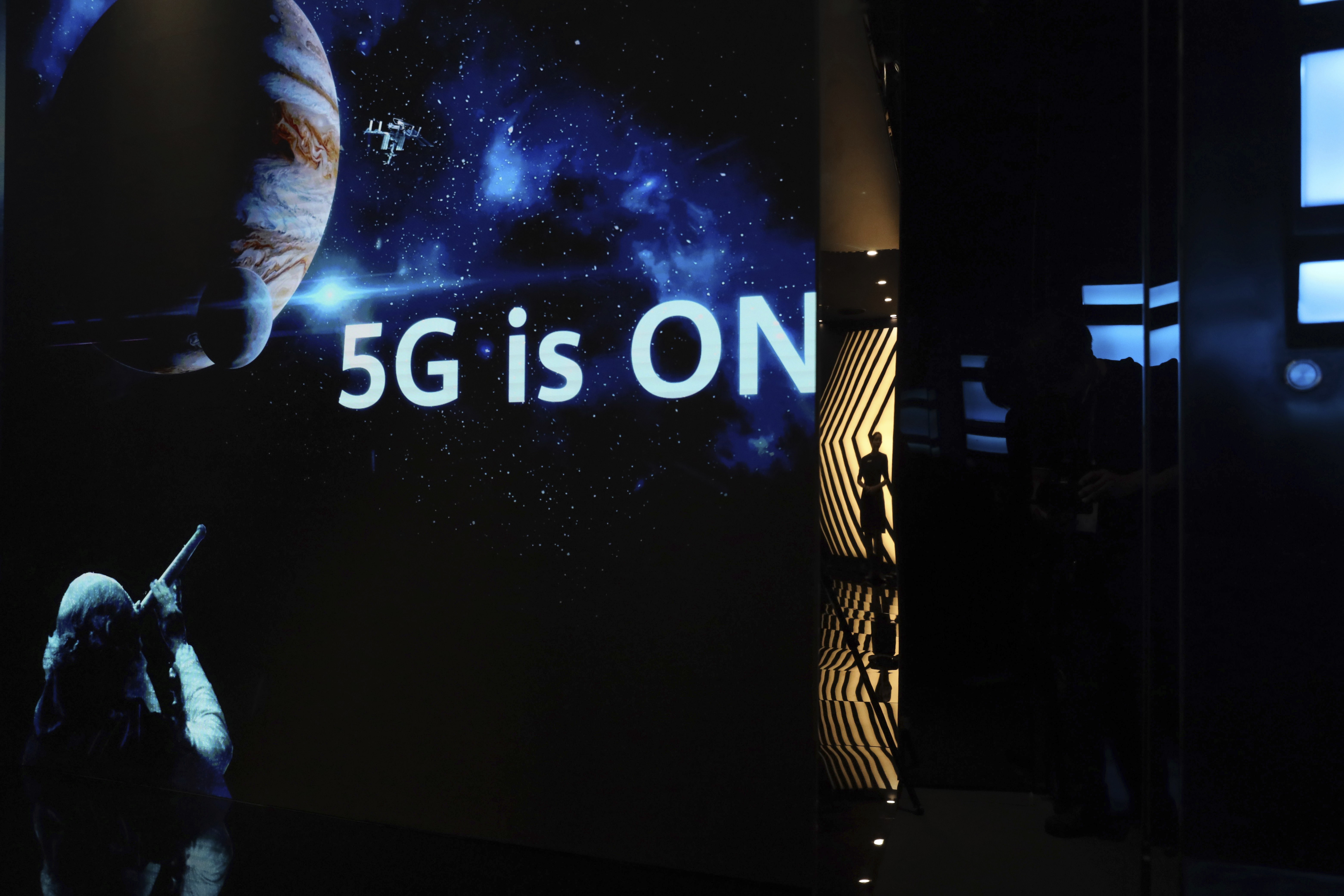 A guide is silhouetted in an exhibition promoting Huawei's 5G technologies in Shenzhen, China. Photo: AP