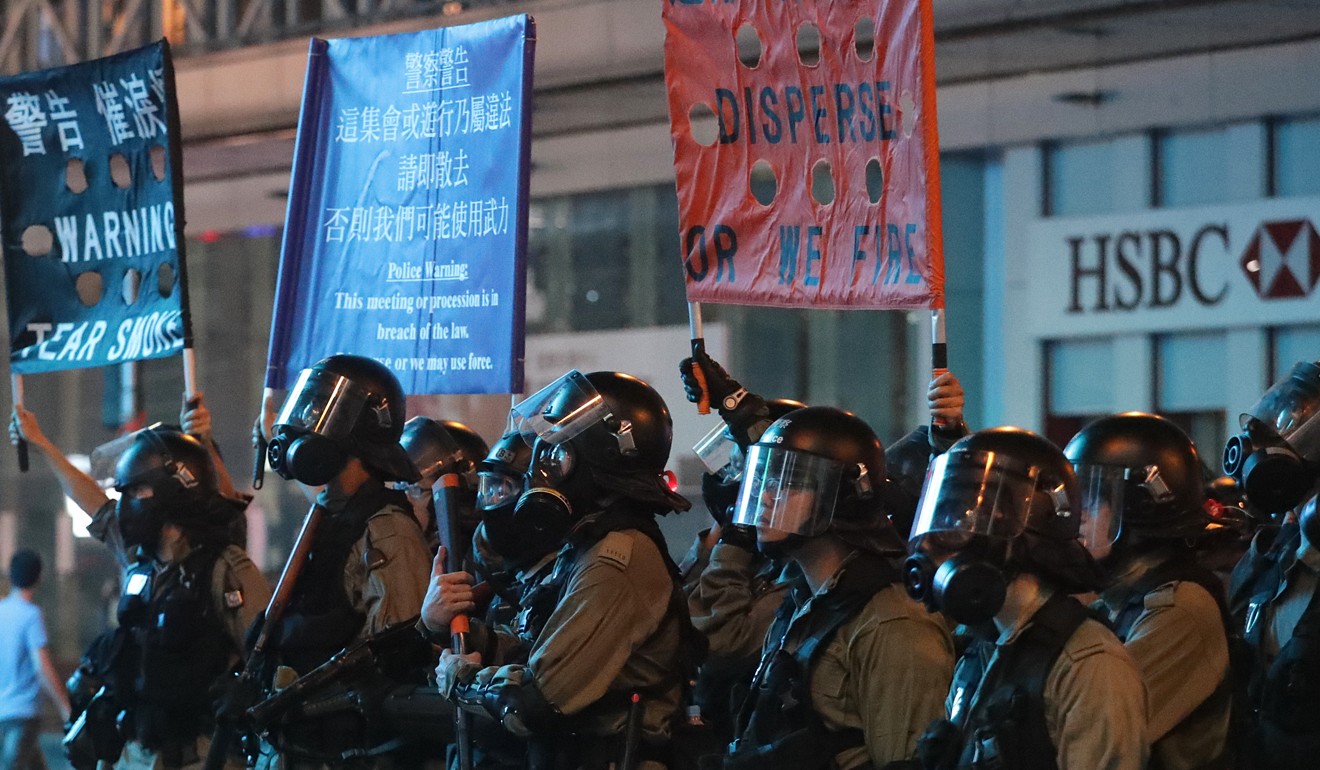 Riot police raise warning flags in a stand-off with protesters. Photo: Edmond So