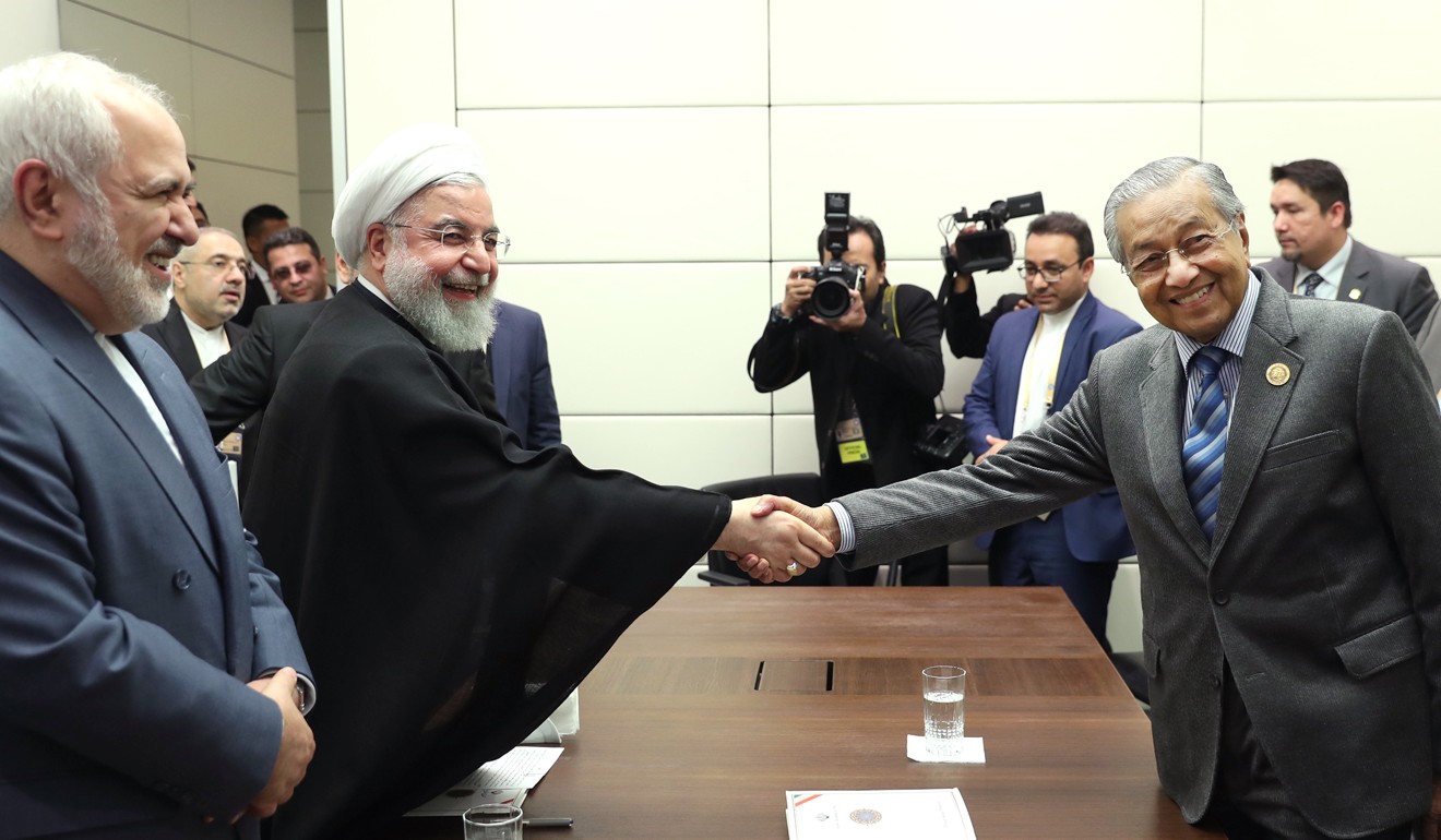Iranian President Hassan Rowhani shakes hands with Malaysian Prime Minister Mahathir Mohamad during a meeting on Friday. Photo: Iranian Presidency/DPA