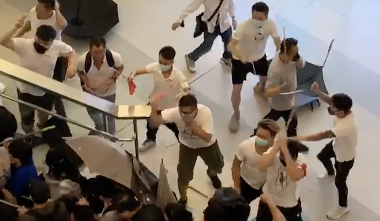 A video grab showing a number of people in white with wooden sticks assaulting passengers arriving at the Yuen Long MTR Station in July. Photo: SCMP