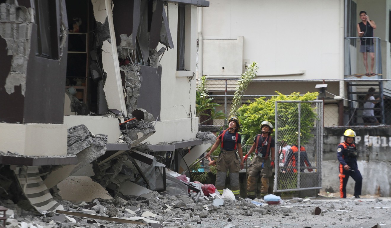 Rescuers look at a damaged condominium building in Davao City after the latest earthquake hit the region. Photo: AFP