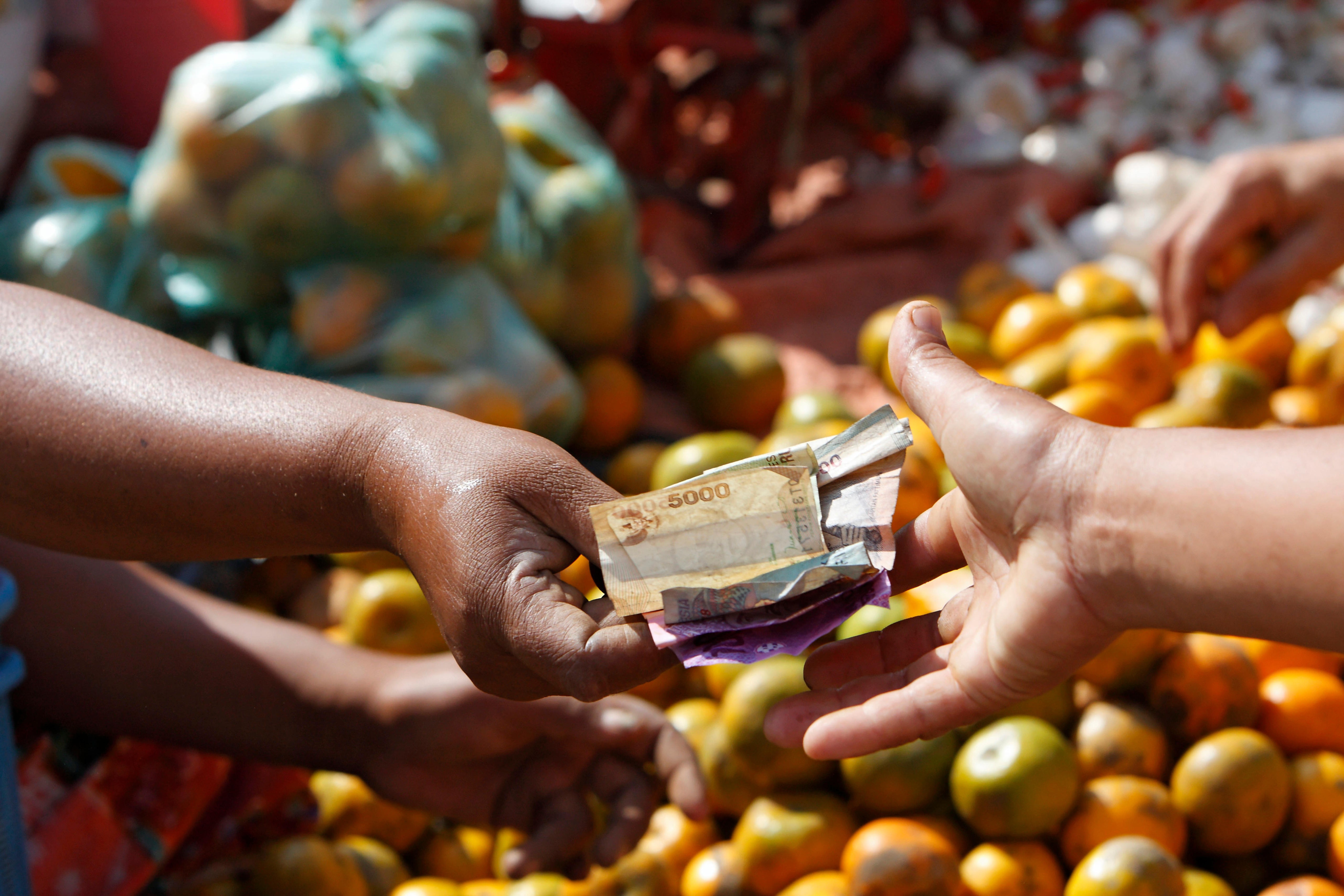 Money changes hands at a market in Lombok, Indonesia. In Indonesia, the left hand is traditionally the one used to clean yourself after going to the toilet. Photo: Alamy