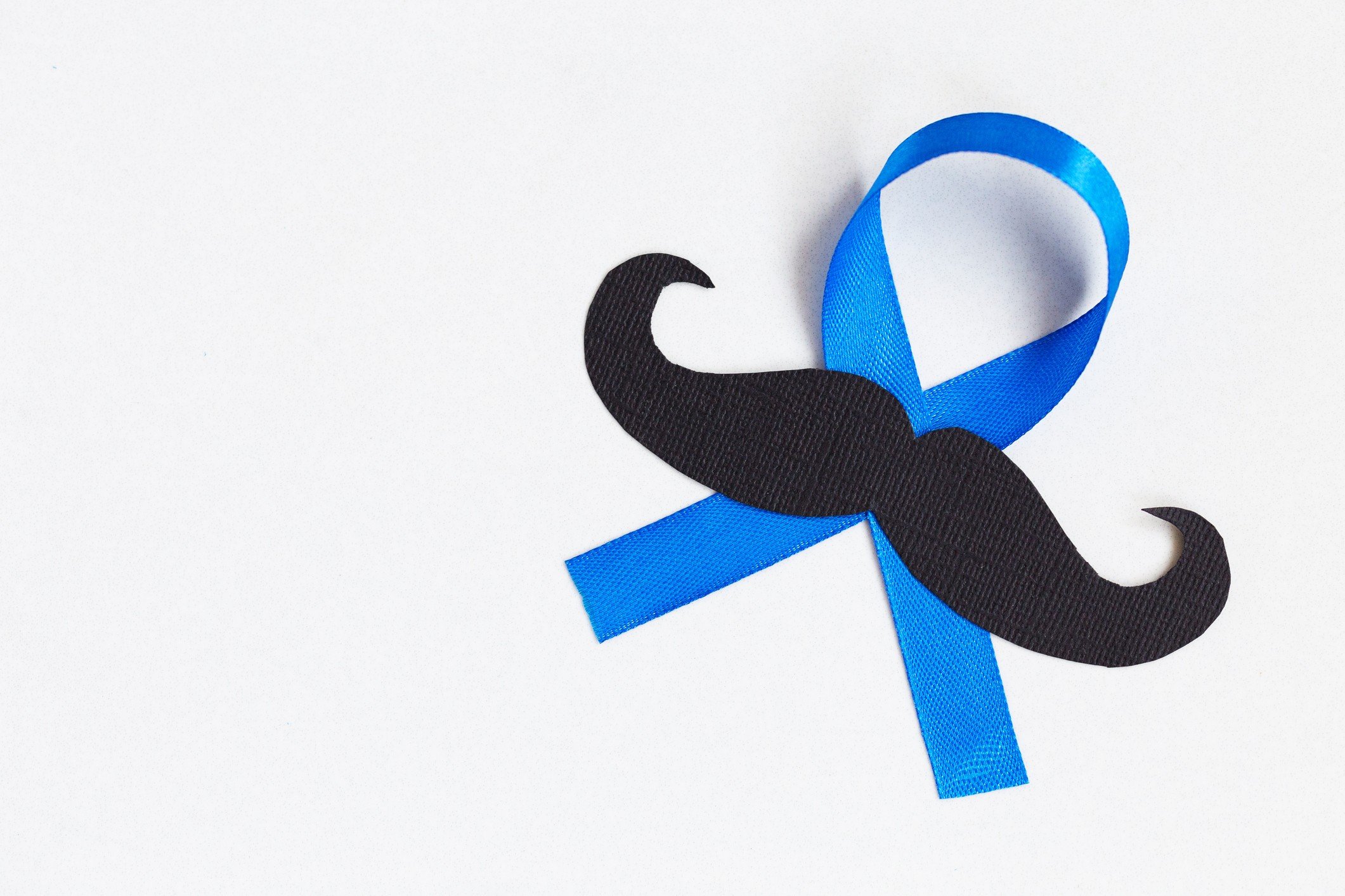 Moustache pattern with blue ribbon symbol is a Movember concept. The Movember movement is to bring awareness to prostate cancer and men’s health in general, including mental health.