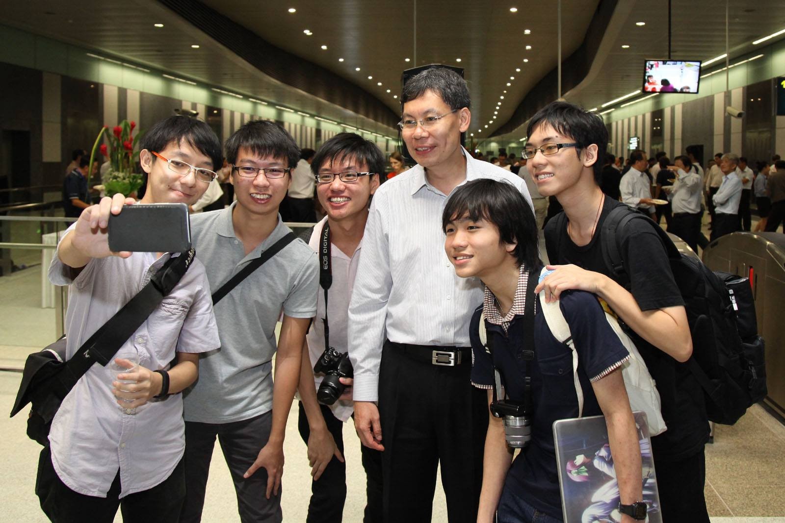 Lui Tuck Yew (fourth from left) with Singapore MRT commuters. Photo: Facebook