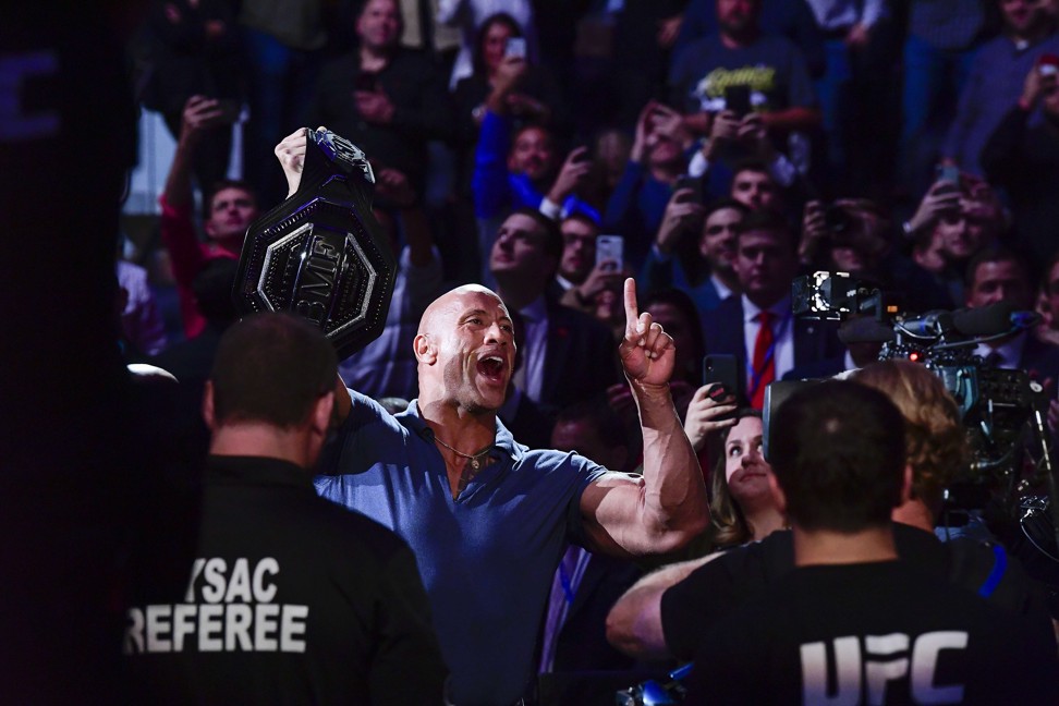 Dwayne ‘The Rock’ Johnson holds the ‘BMF’ belt on his way to the Octagon. Photo: AFP
