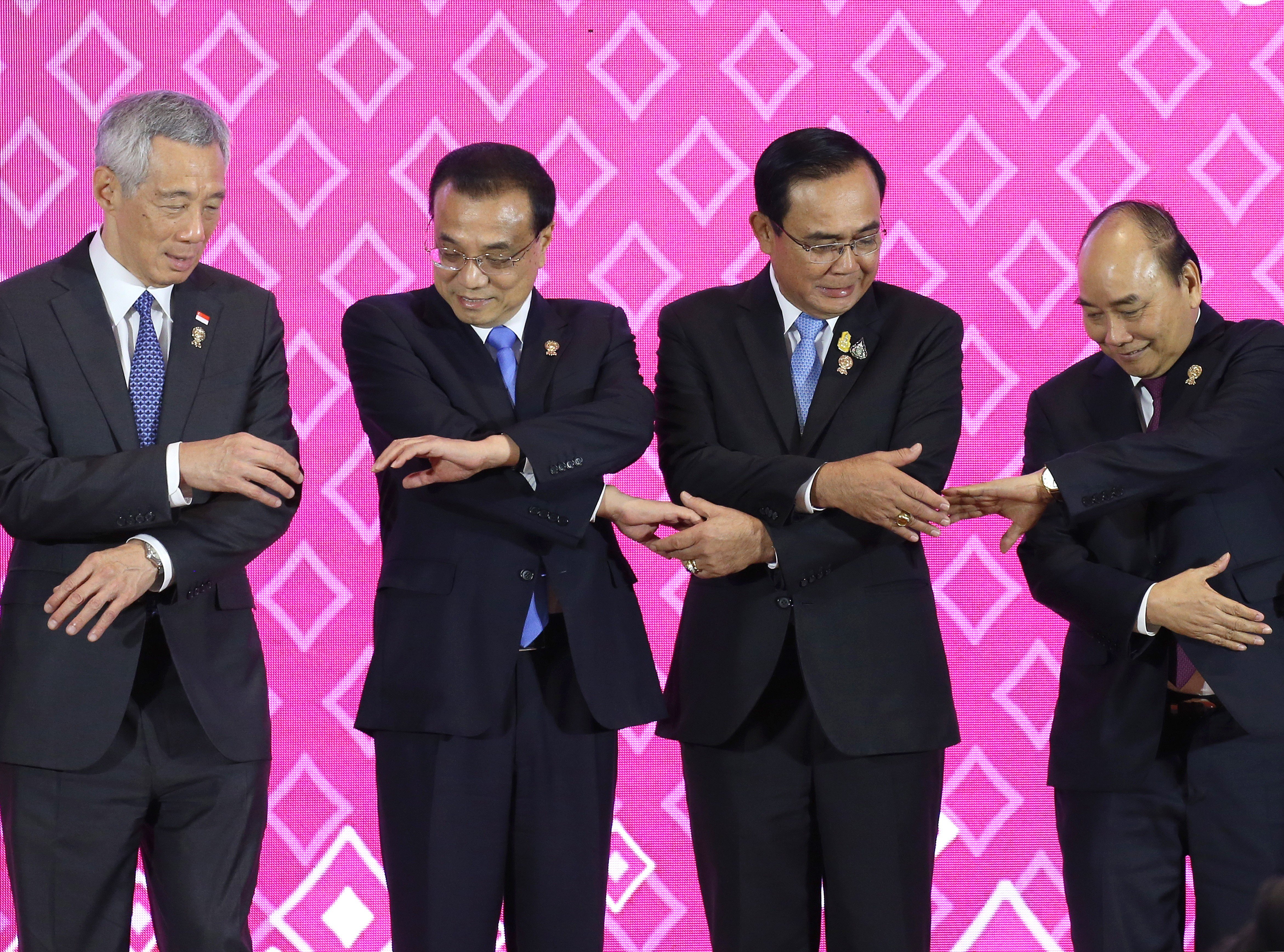 Singapore's Prime Minister Lee Hsien Loong, China's Premier Li Keqiang, Thailand's Prime Minister Prayuth Chan-ocha and Vietnam's Prime Minister Nguyen Xuan Phuc link hands to pose for a group photo during the 22nd Asean – China Summit in Bangkok. Photo: EPA