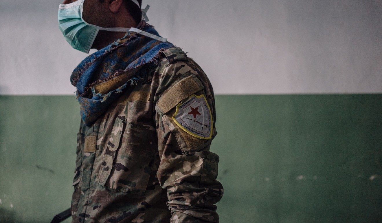 A member of the Kurdish-led Syrian Democratic Forces stands guard. Photo: Alice Martins for The Washington Post