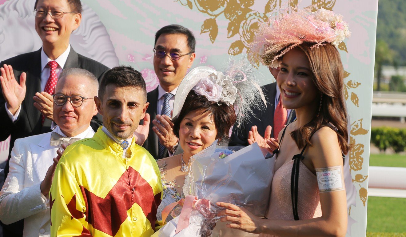 Kelly Cheung presents the trophy to jockey Alberto Sanna.