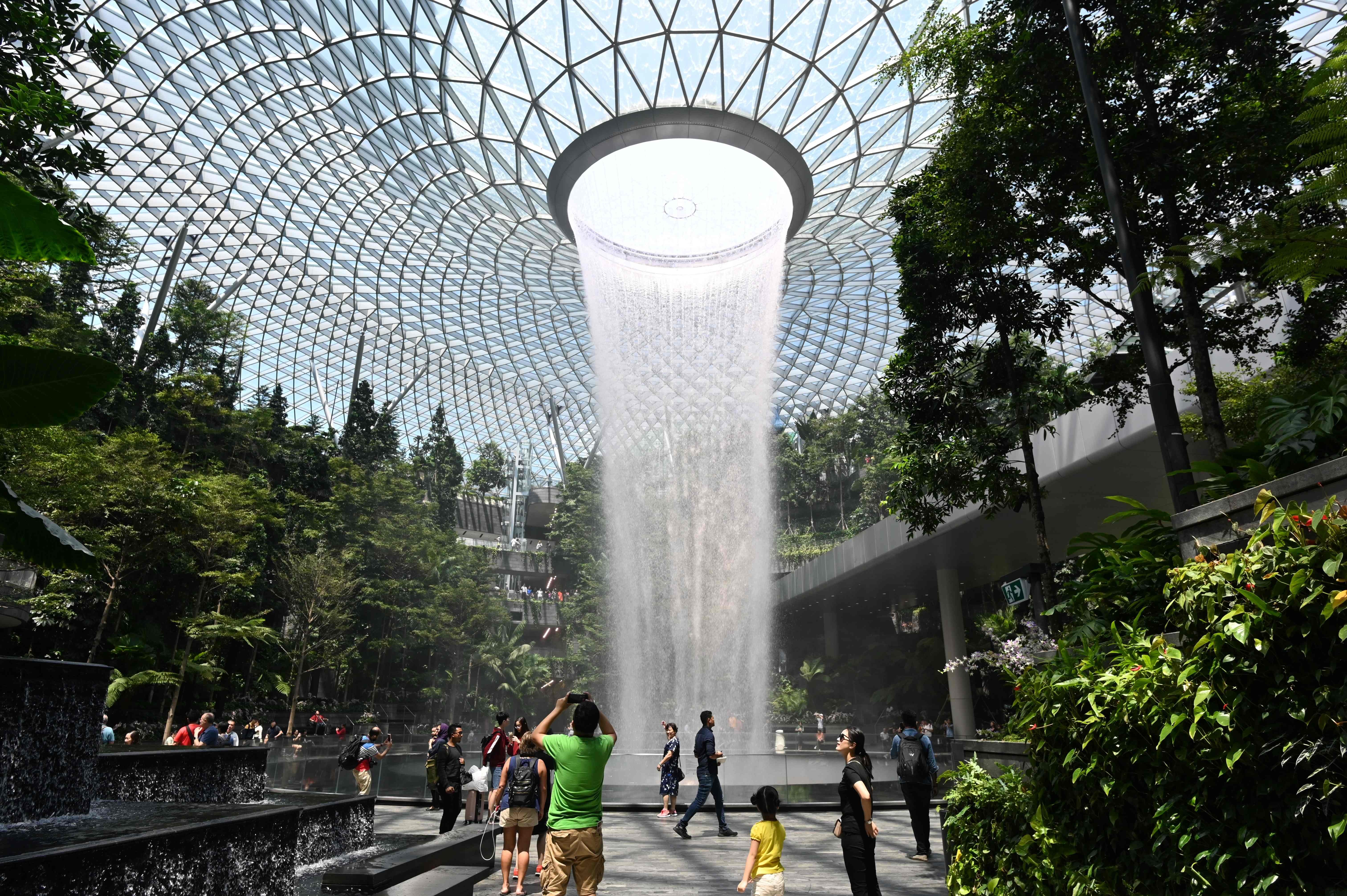 Visitors take photographs of the ‘Rain Vortex’ at Jewel Changi in Singapore on Wednesday. Photo: AFP