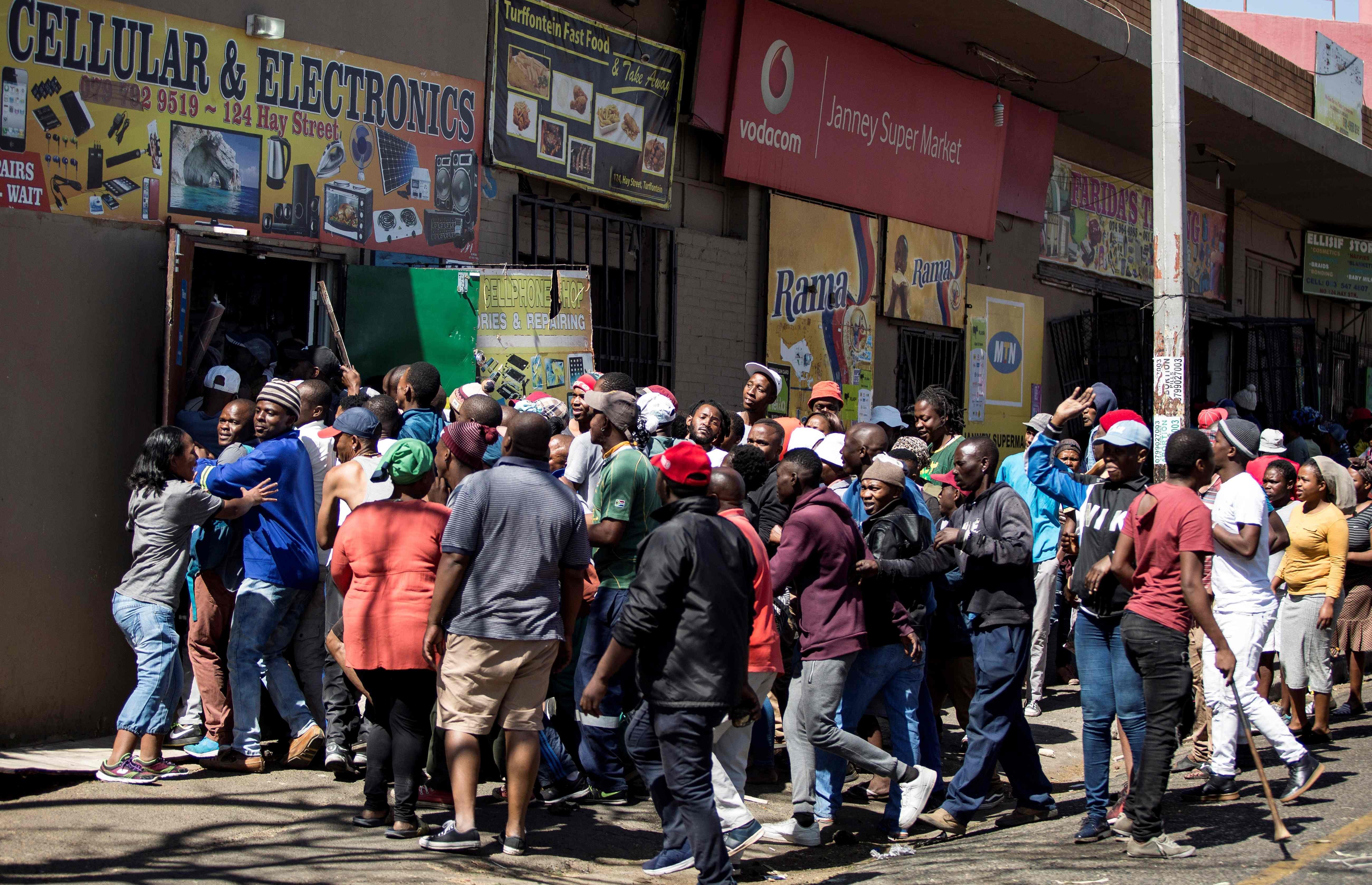 South African looters take items from foreign-owned shops during a riot in Johannesburg in September. Photo: AFP
