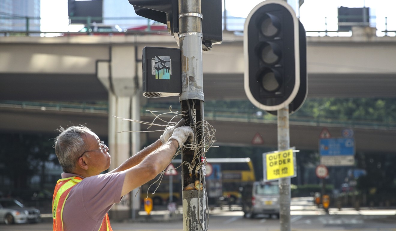 A worker repairs broken traffic lights in Causeway Bay. Photo: Winson Wong