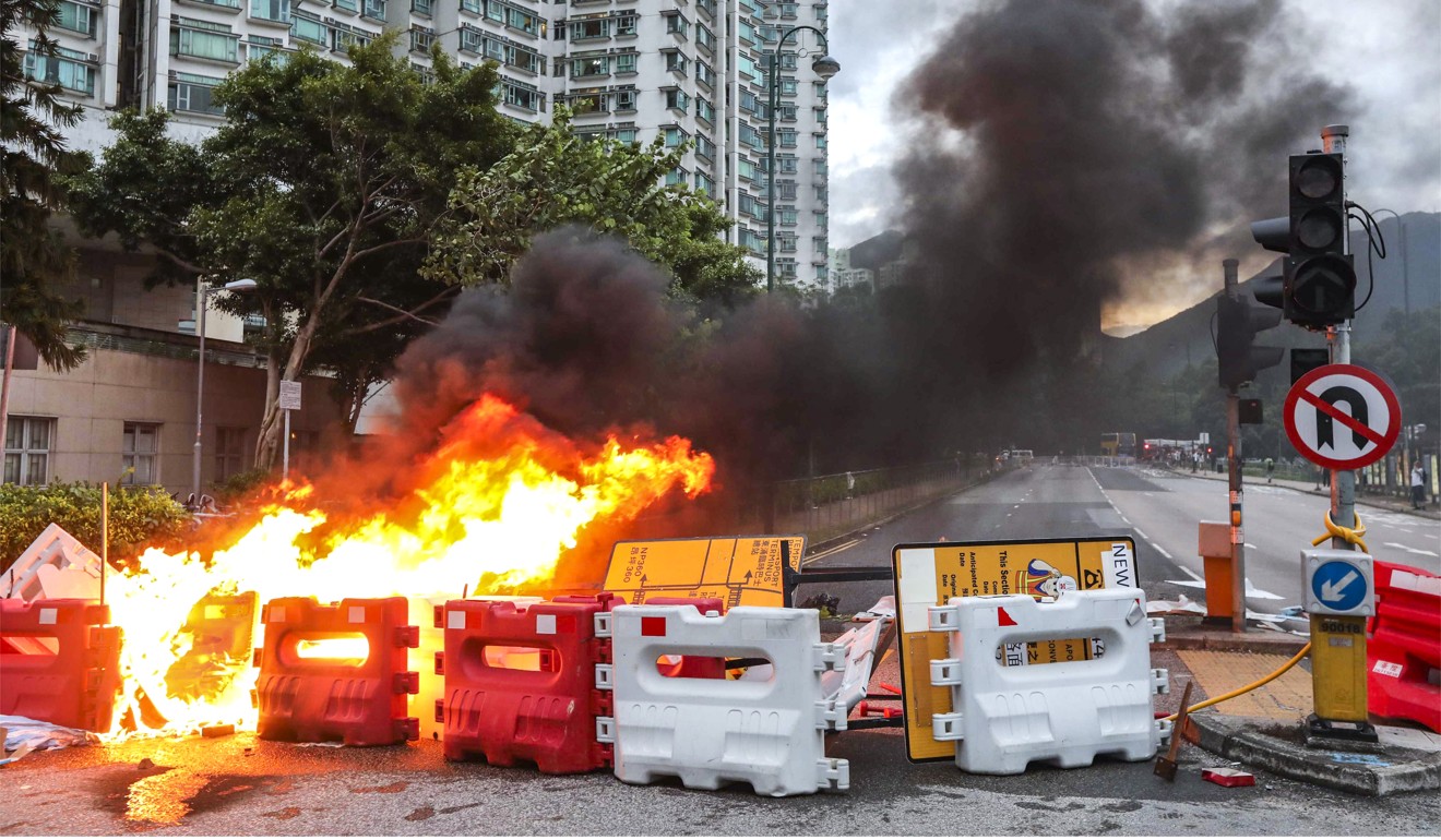 Plastic barriers are torched during a protest in Tung Chung. Photo: Felix Wong