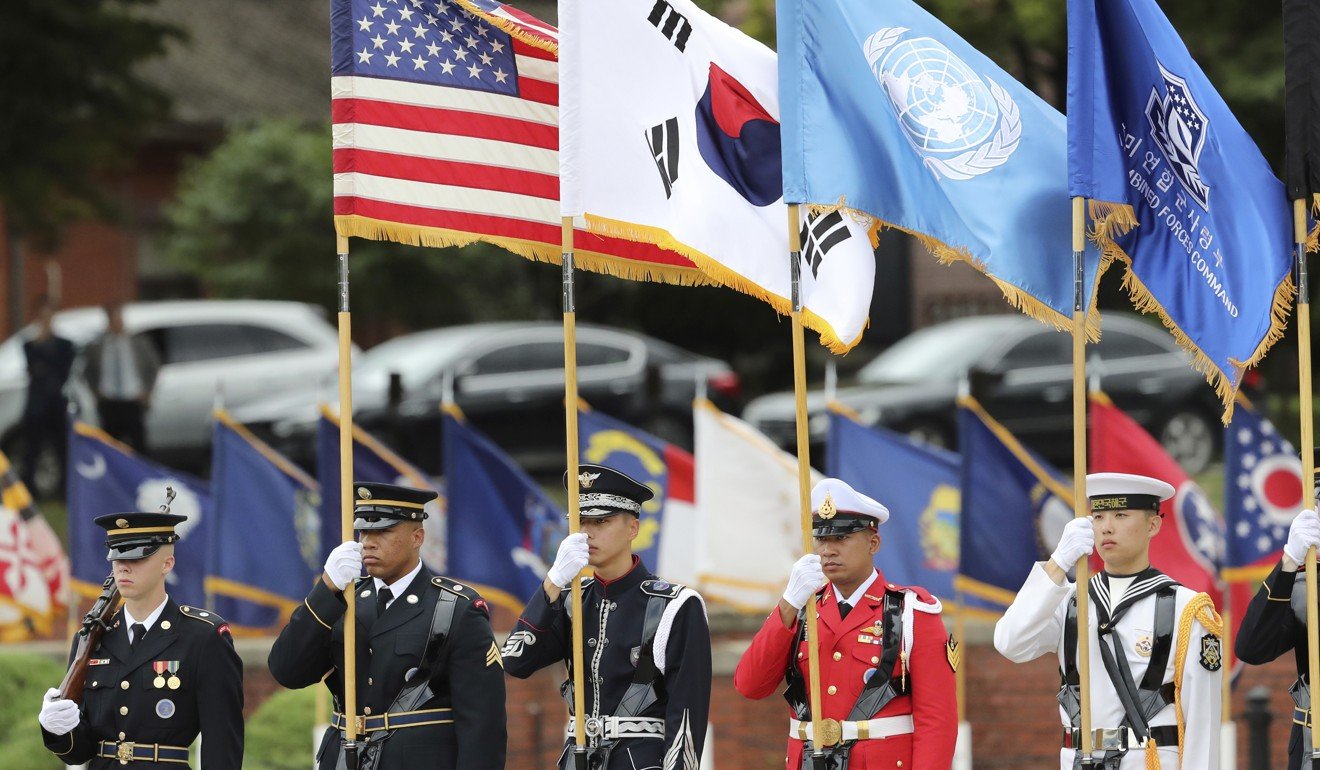 UN Command honour guards carry flags of the United States, the United Nations and South Korea during a change of command at Yongsan. Photo: AP