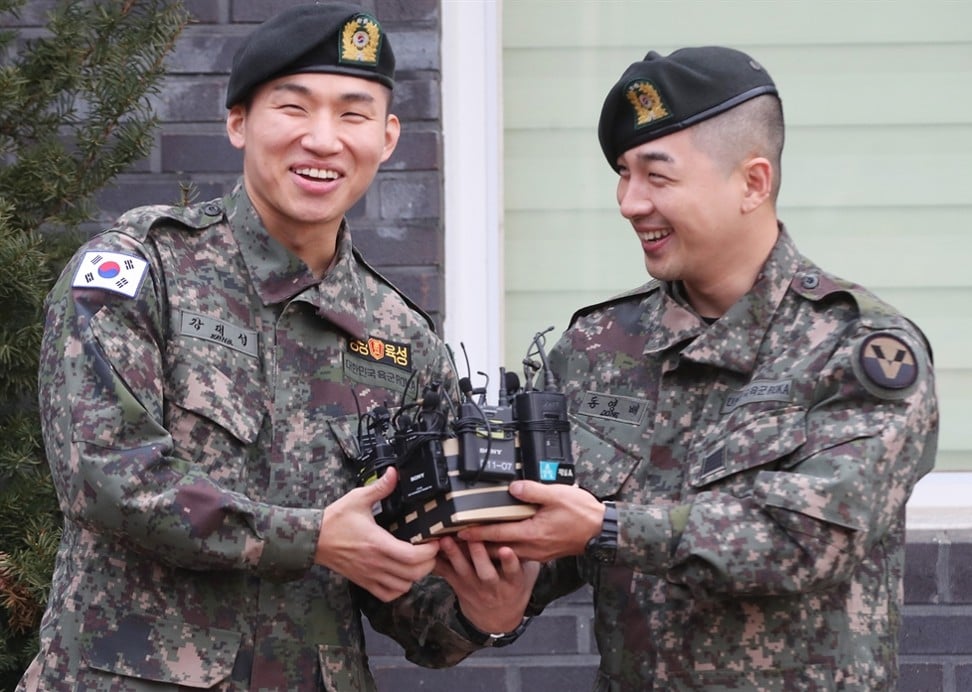Daesung and Taeyang smile during their discharge ceremony in Yongin, Gyeonggi