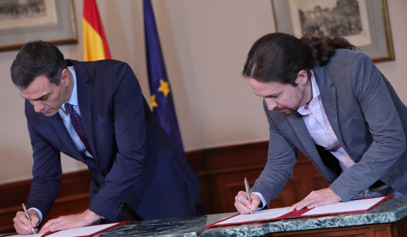 Spanish Prime Minister Pedro Sanchez and leader of the Unidas Podemos party Pablo Iglesias sign the principles of agreement to share a coalition government. Photo: DPA