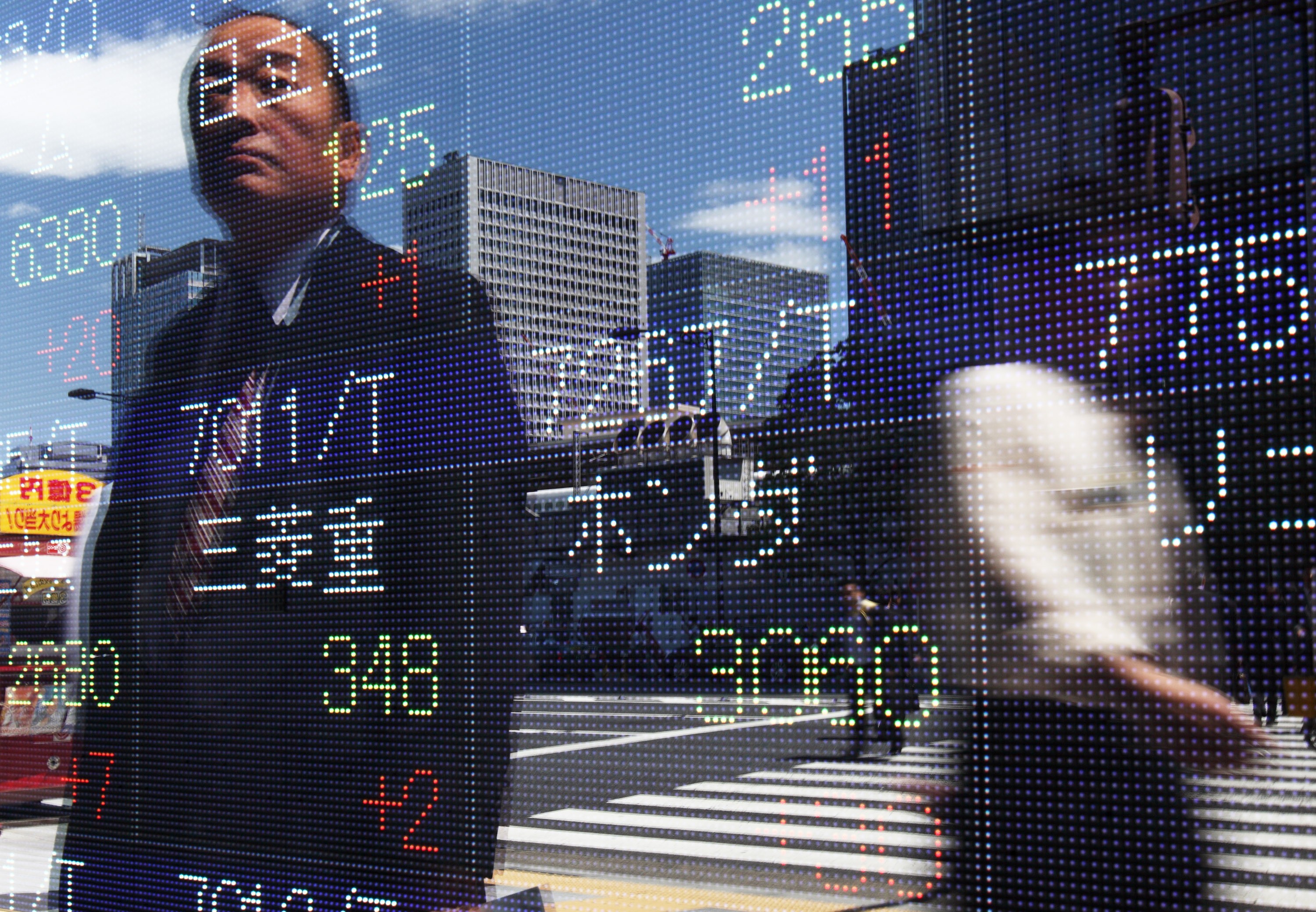 Pedestrians are reflected in an electronic stock board in Tokyo, Japan, in 2010. Research shows that just over half of active managers outperformed a broad range of US indices during the dotcom crash in the early 2000s. Photo: Bloomberg