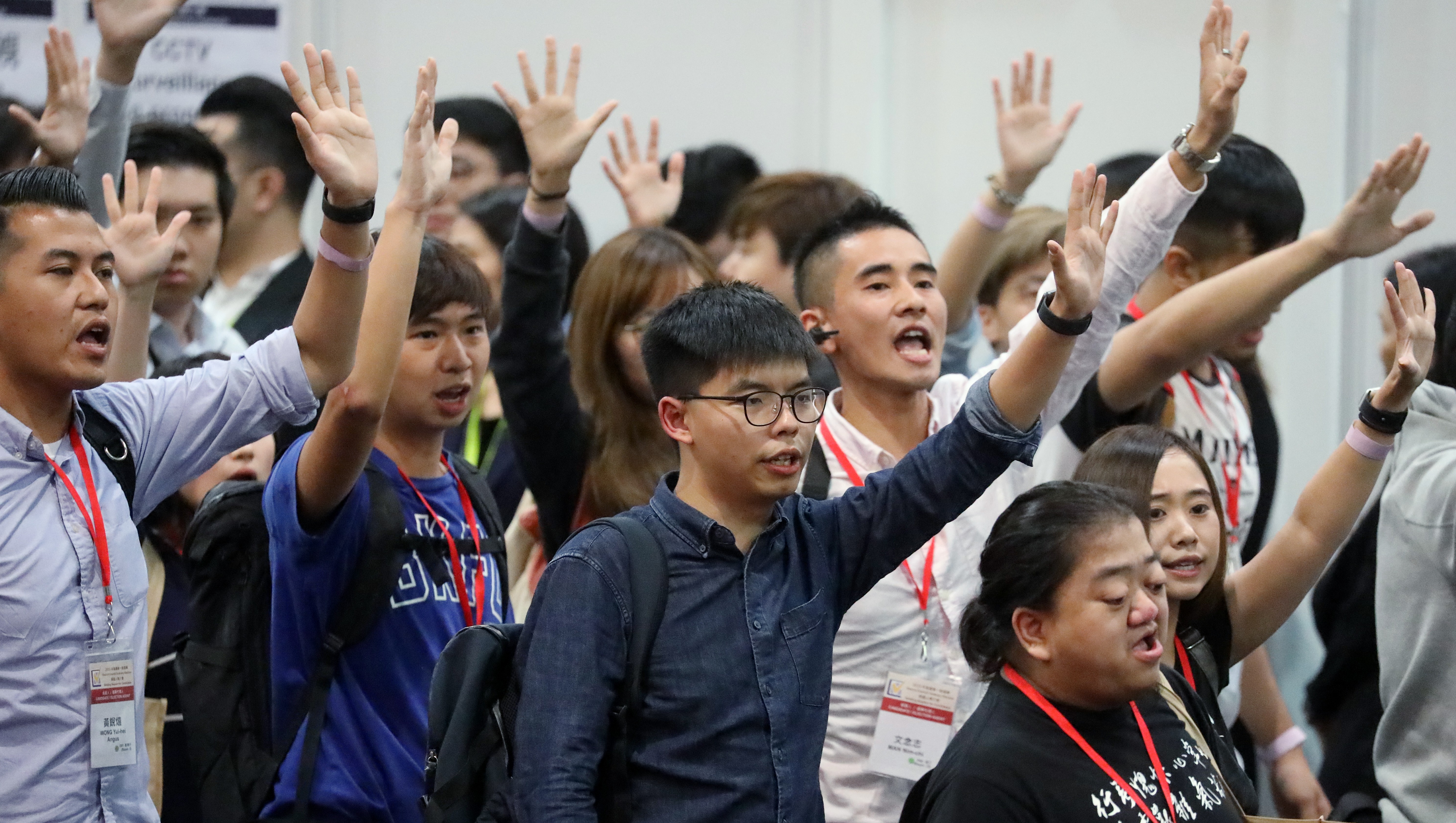 Activist Joshua Wong Chi-fung (centre) holds up five fingers to represent the five demands of anti-government protesters, at a briefing session for the district council elections, hosted by the Electoral Affairs Commission at AsiaWorld-Expo in Chek Lap Kok on October 24. Wong’s application to run was rejected a few days later. Photo: K.Y. Cheng