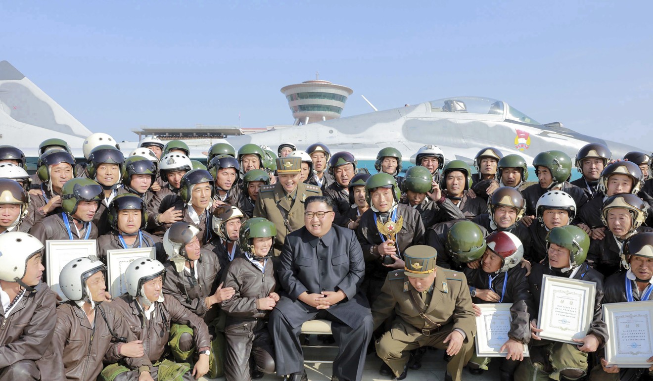 North Korean leader Kim Jong-un poses with pilots at an airfield in North Korea. Photo: AP