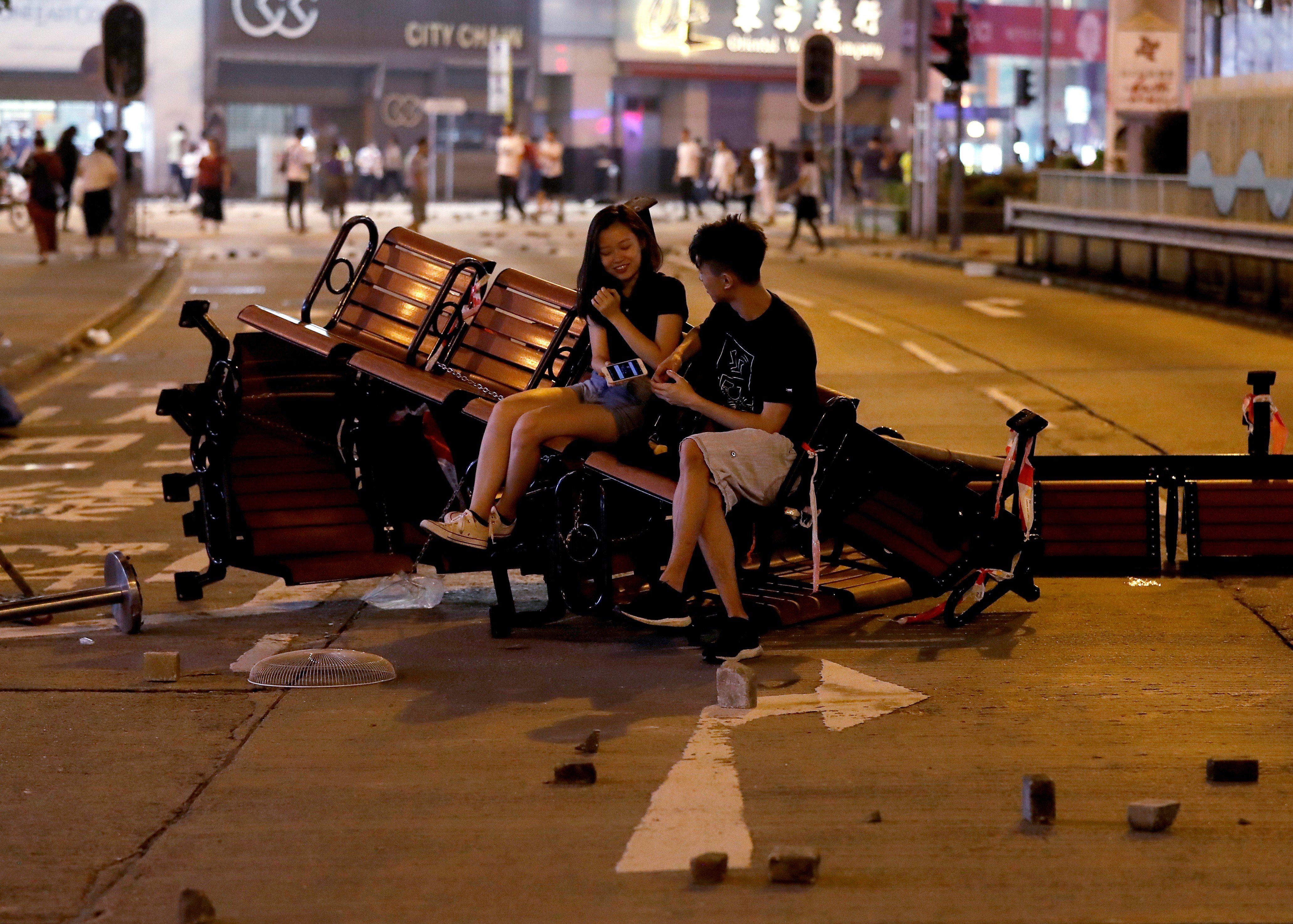 People sit on a barricade made of benches left after an anti-government protest in Hong Kong, on October 20. Photo: Reuters