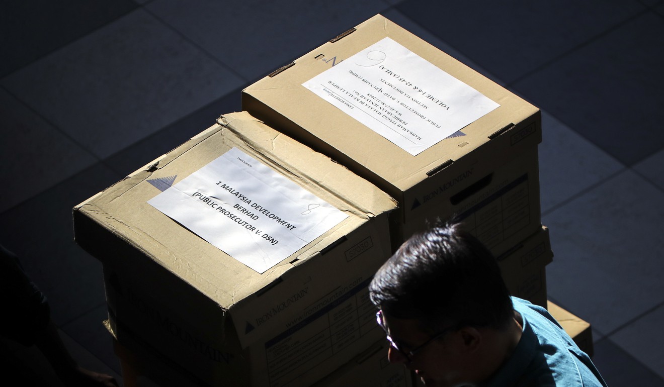 A man carries boxes of documents related to one of Najib’s trials. Photo: EPA