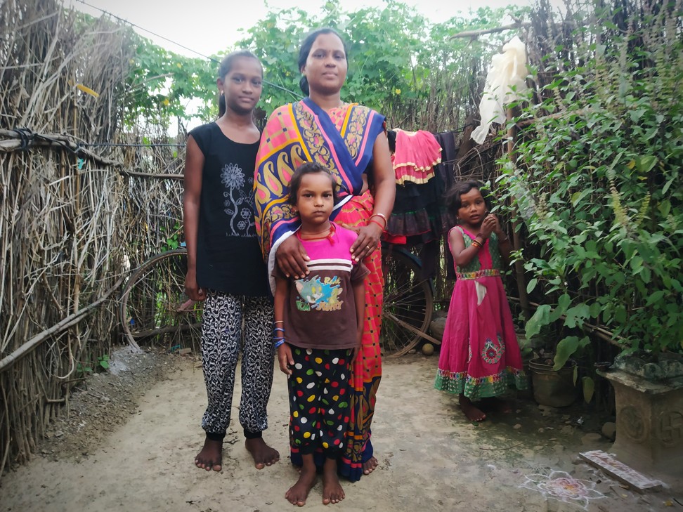 Manisha Uke, in her newly-built house made of mud, dried twigs and cloth, with her children. Photo: Kunal Purohit