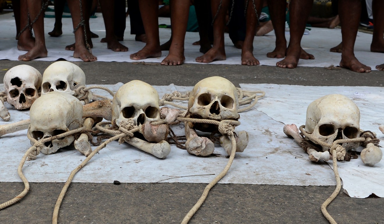 Indian farmers from Tamil Nadu state stand next to the skulls of farmers who killed themselves, during a protest in New Delhi. Photo: AP