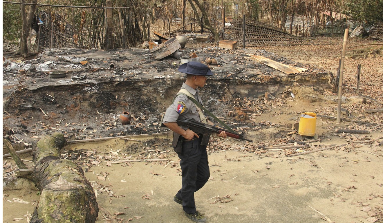 A Myanmar security officer walks past burnt Rohingya houses in Ka Nyin Tan village in Maungdaw, northern Rakhine state. Photo: AP