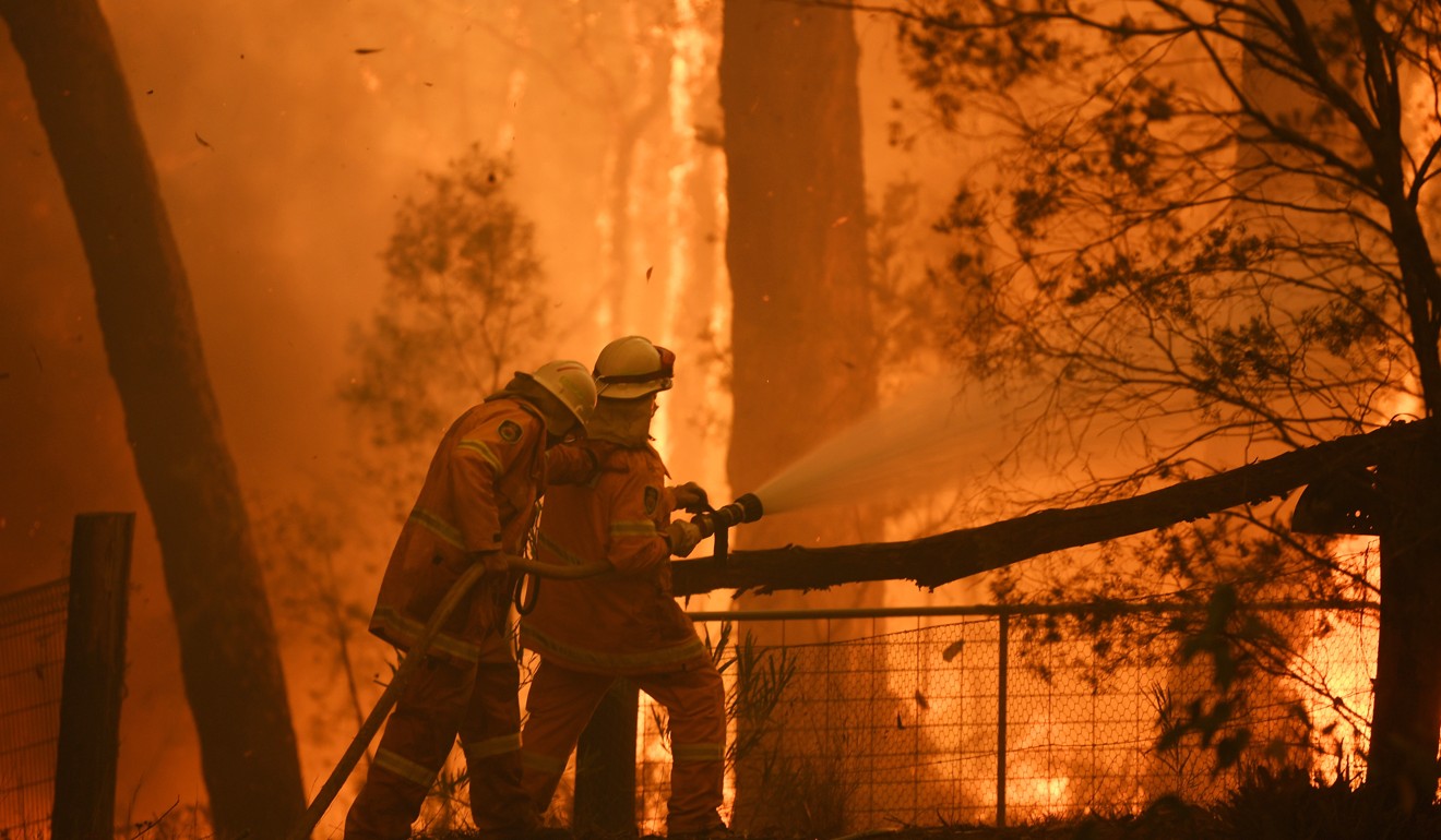 Firefighters protect a home southwest of Sydney. Photo: EPA