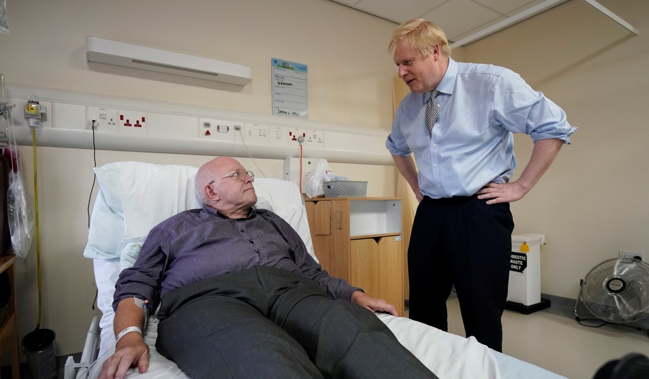 Britain's Prime Minister Boris Johnson meets a patient in hospital. Photo: Reuters